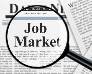 Job market headline under magnifying glass