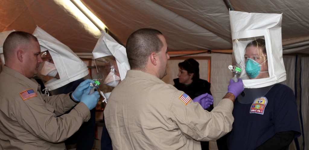 Staff of the National Disaster Medical System performing respirator Fit tests on other staff members who are wearing N95 masks and have hoods on.